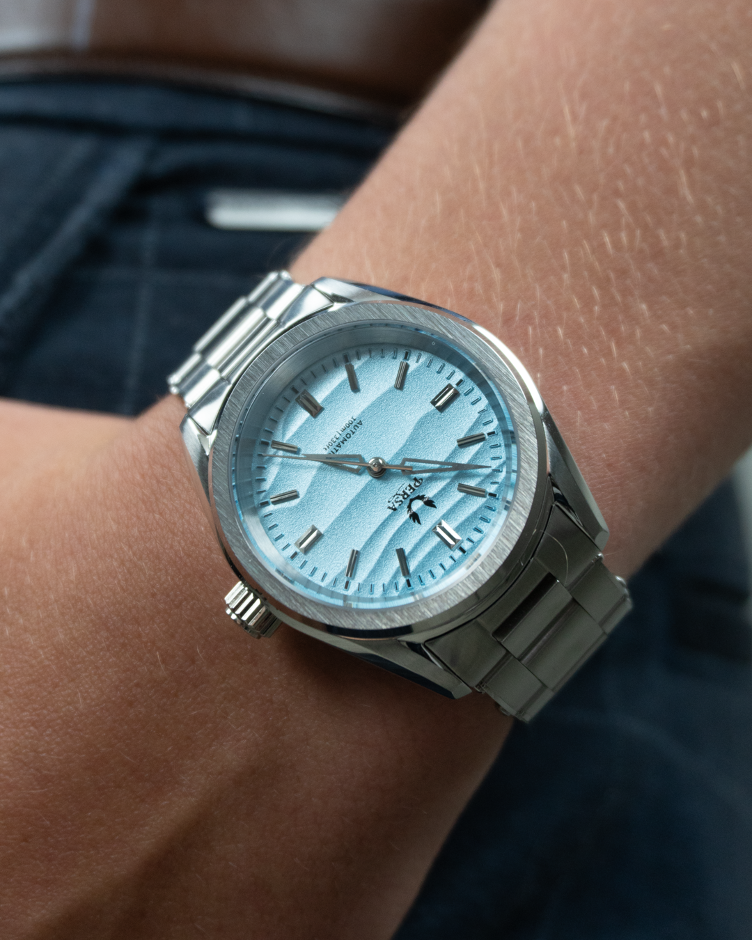 Azure blue dial stainless steel watch on wrist